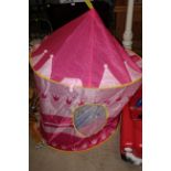 A pop up Princess castle in pink and white, with yellow rims and flag,