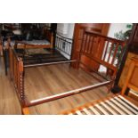 A 1940's oak double bed with moulded central splat and three vertical splats between barley twist