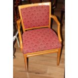 Pair of vintage lightwood upholstered armchairs in repeating maroon pattern with concave backs and