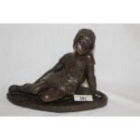 A cast resin figure of a reclining child, unmarked but in the manner of Heredities, 20 cm long.