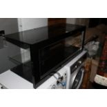 A modern black and clear glass rectangular TV / media stand, with central clear glass shelf,