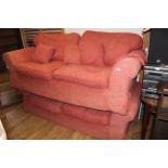 Two Laura Ashley three seater settees, upholstered in terracotta and foliate patterned material.