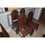 A set of four 1920's oak and studded brown leather dining chairs with arched crest rails and turned