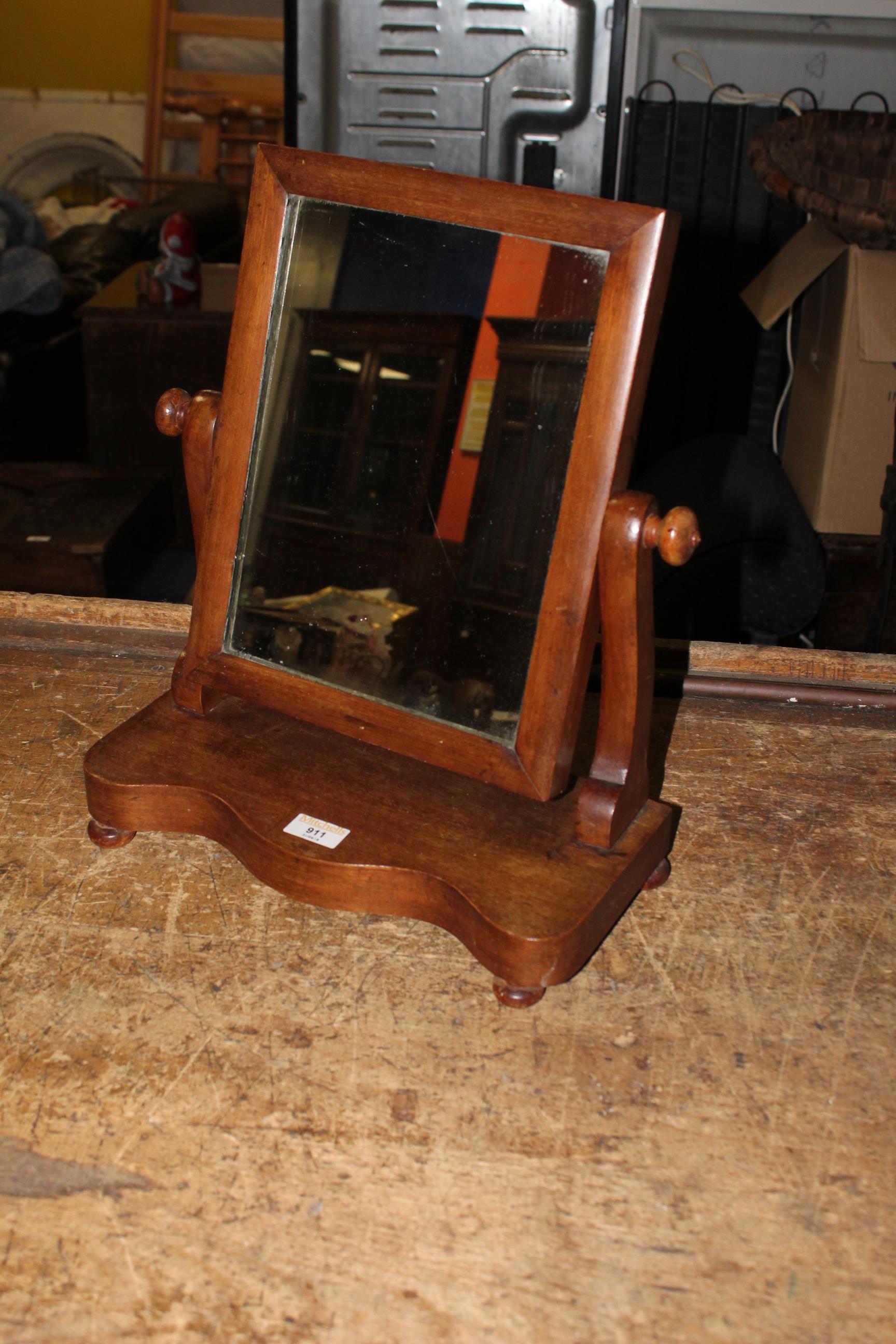 A Victorian mahogany rectangular toilet mirror of small proportion on scrolled uprights and
