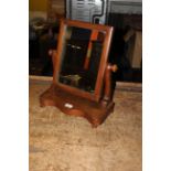 A Victorian mahogany rectangular toilet mirror of small proportion on scrolled uprights and