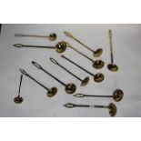 A collection of 12 19th century brass ladles with circular bowls, mostly with slotted terminals,
