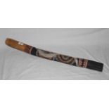 An Australian didgeridoo painted in grey with a snake on black ground with dotted decoration,