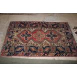 A 19th century North West Persian rug having a central panel of three stylised guls enclosed by
