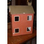 A vintage dolls house, formed as a red bricked town house with four windows, 78 x 61 x 36 cm.