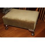 A 1920's oak footstool upholstered in green Draylon, 56 x 39 x 28 cm high.