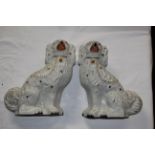 A pair of Staffordshire pottery spaniels decorated in gilt to highlights, 32 cm high.