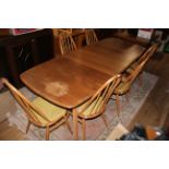 An Ercol light elm extending dining table fitted single folding leaf on square angled legs,