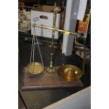 A set of late Victorian brass beam scales mounted to a moulded mahogany platform and sold with a