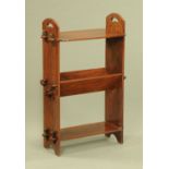 A mahogany Arts and Crafts book trough and combined shelf unit, with pegged brackets.
