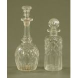 A club shaped cut glass decanter, and a cylindrical decanter.