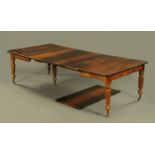 A Regency / William IV solid rosewood extending dining table with four leaves and raised on turned