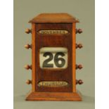 An oak cased perpetual desk calendar. Height 22.5 cm, width 14 cm.