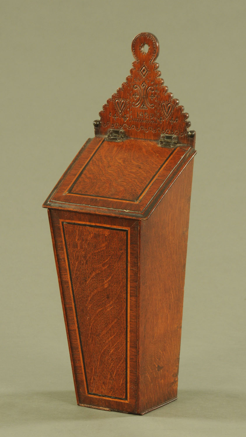 An early 19th century oak and mahogany crossbanded boxwood and ebony strung candle box, dated 1829.