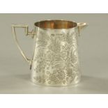 A late Victorian silver cream jug, foliate engraved, Sheffield 1899,