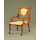 An Edwardian inlaid mahogany armchair, with scroll arms and shaped sabre type front legs.