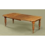 A late Victorian oak extending dining table, fitted with two leaves, with moulded edge,
