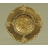 An Art Nouveau bronze dish, decorated in slight relief with a young lady's head. Diameter 31 cm.