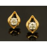 An 18 ct two tone gold pair of stud earrings, set with diamonds weighing +/- .52 carats.