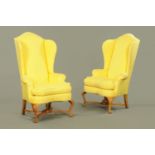 A pair of wing chairs, of large form, in the Queen Anne style, with rollover arms,