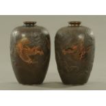 A pair of Japanese bronze vases, decorated with chasing dragons. Height 26 cm.
