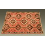 An Eastern rug, the centre rectangular panel with repeating designs and with slim border,