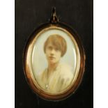 A 9 ct gold oval locket, initialled and housed in an ebonised frame,
