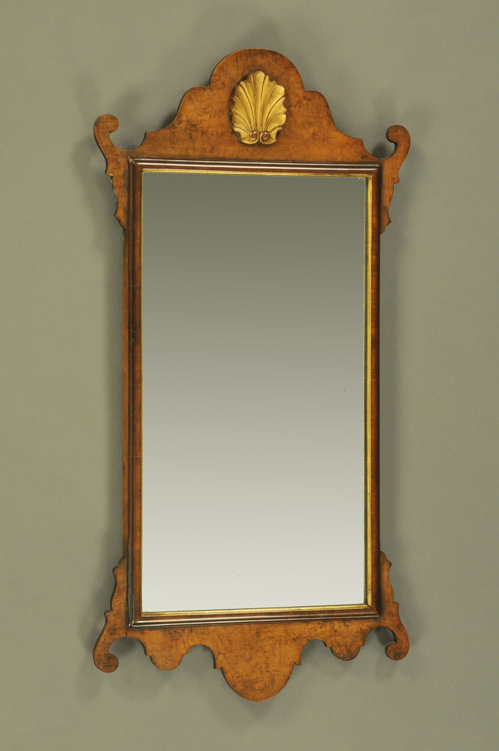 A Chippendale style walnut fretwork wall mirror, with gilt shell to head. Height 86 cm, width 44.