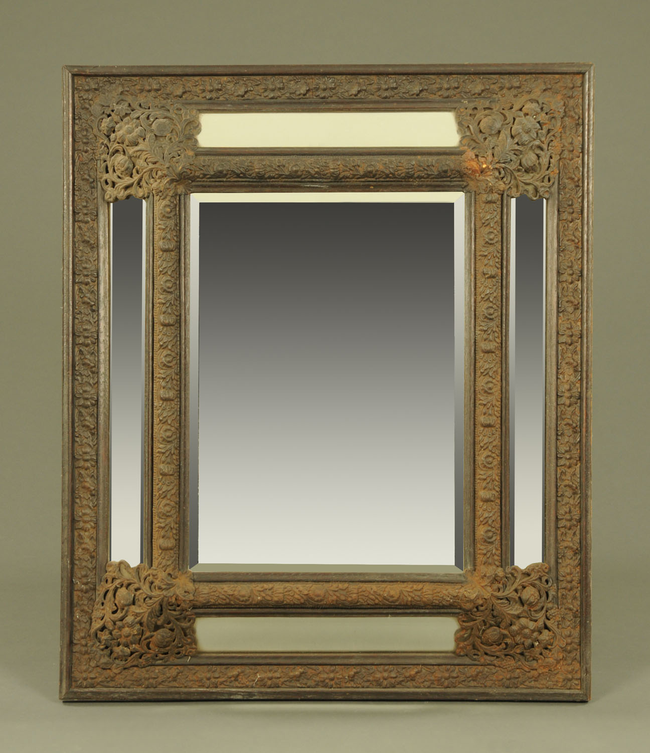 A 19th century continental metal and oak framed cushion fronted mirror, with bevelled glass panels.
