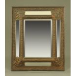 A 19th century continental metal and oak framed cushion fronted mirror, with bevelled glass panels.