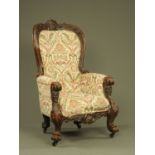 A large Victorian gentleman's armchair, with carved exposed frame,