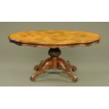 A Victorian style walnut shaped low occasional table with moulded edge and raised on a turned