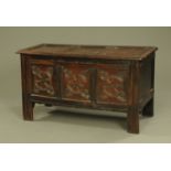 An antique oak three panelled coffer, with carved front and raised on stile feet.