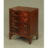 A mahogany serpentine chest of four drawers, with brass drop handles and raised on bracket feet.