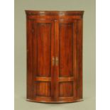 A 19th century mahogany bow fronted hanging corner cupboard,