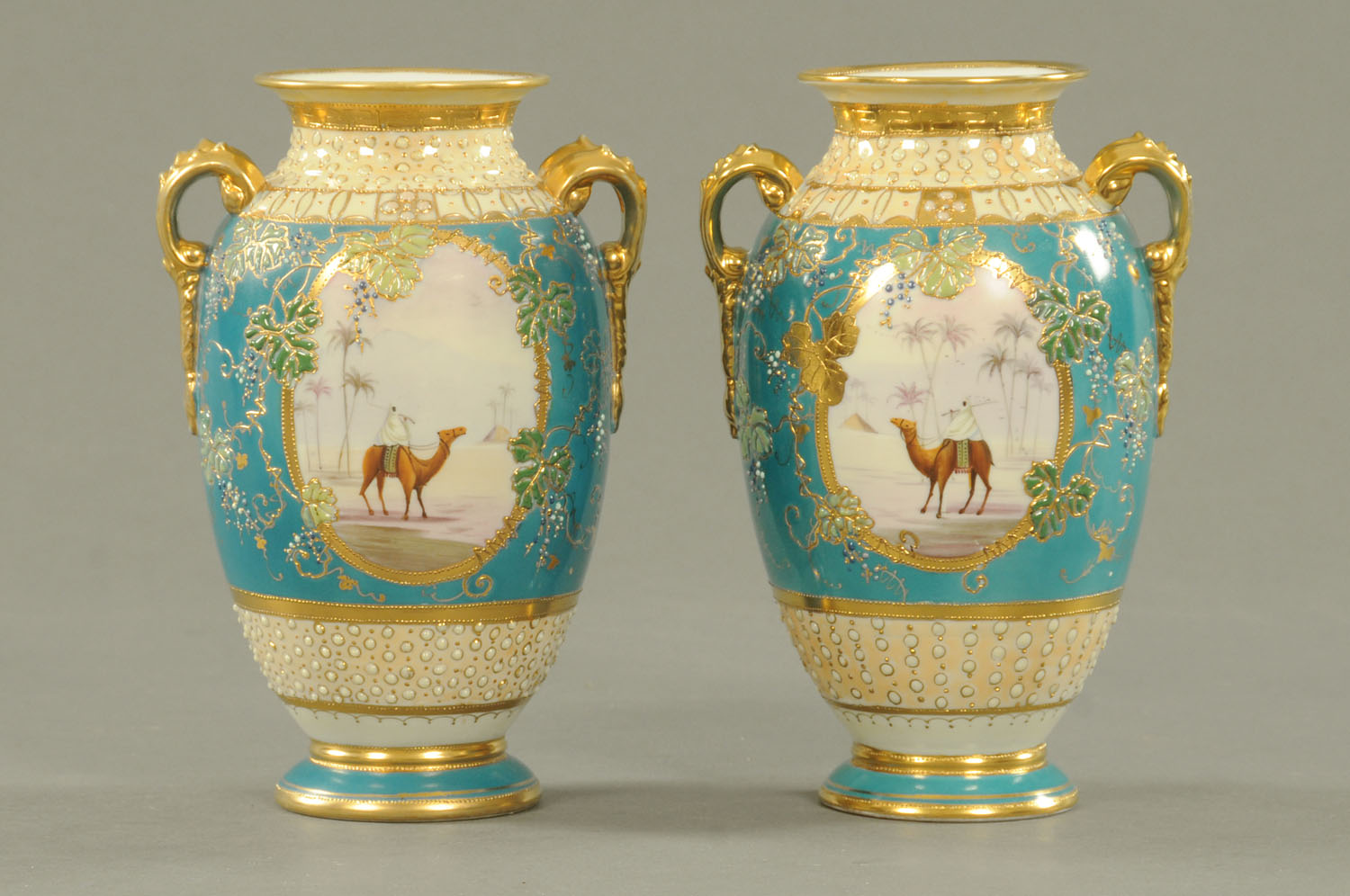 A pair of Noritake vases, decorated with panels of eastern scenes,