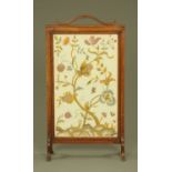 A needlework panelled oak fire screen, raised on scroll legs. Width 59 cm.