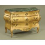 A French style gilt painted serpentine fronted commode chest of drawers, with green marble top.