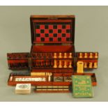 A Victorian walnut cased games compendium, opening to chess men, draughts, cribbage, dominoes.