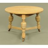 A large circular oak cricket type table, with angled bulbous legs united by stretchers.