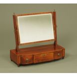 An early 19th century mahogany toilet mirror, the rectangular mirror with angled supports,