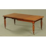 A Victorian mahogany extending dining table with two leaves,