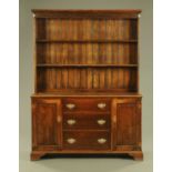 A 19th century oak dresser with Delft rack, with moulded cornice above a series of shelves,