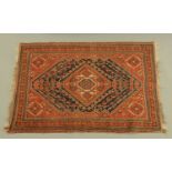 An antique Qashgai rug, woven in red and blue with lozenge field and multiple line border.