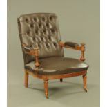 A Victorian walnut armchair upholstered in brown leather,