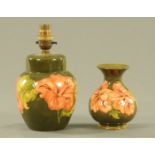 A Moorcroft green ground pottery table lamp base and similar vase,